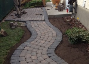 Build out a curving pathway of interlock unistone along side of a hosue